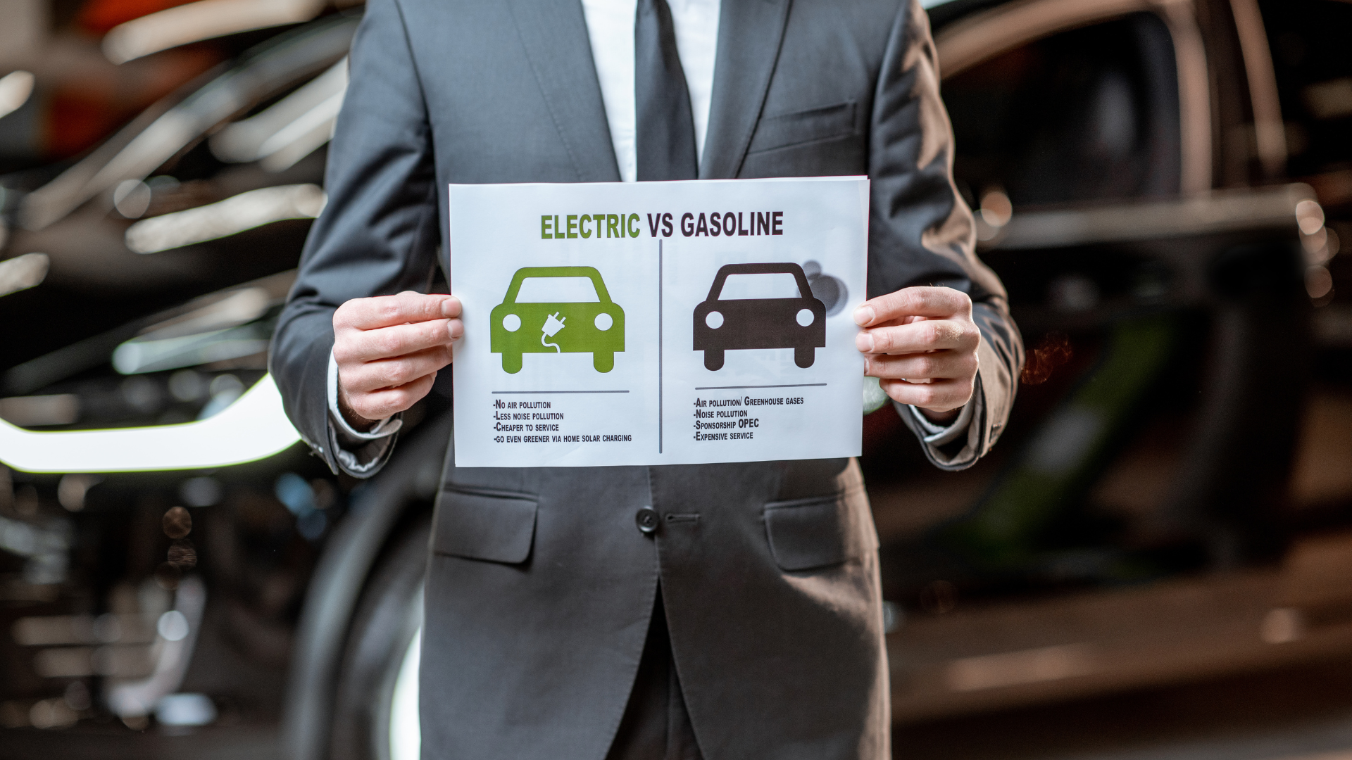 Personne tenant une pancarte sur voiture électrique versus voiture thermique en entreprise